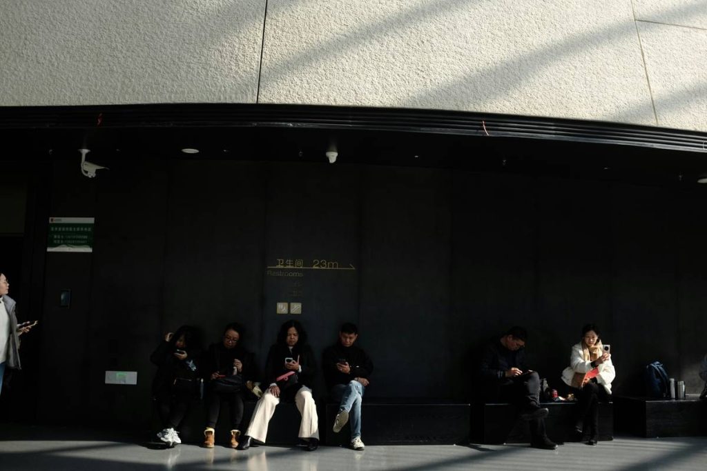People sitting in a dark waiting area with sunlight