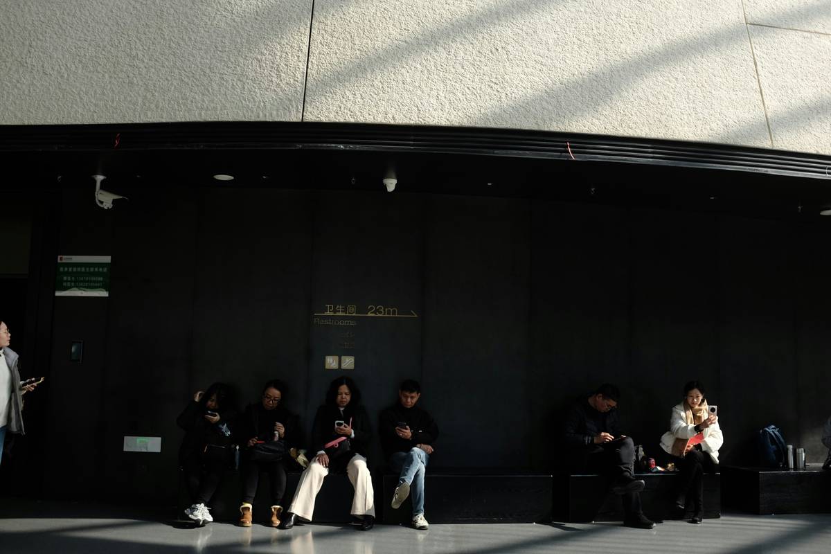 People sitting in a dark waiting area with sunlight